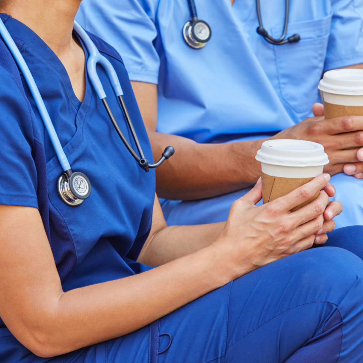 medical professionals having coffee while wearing stethoscopes