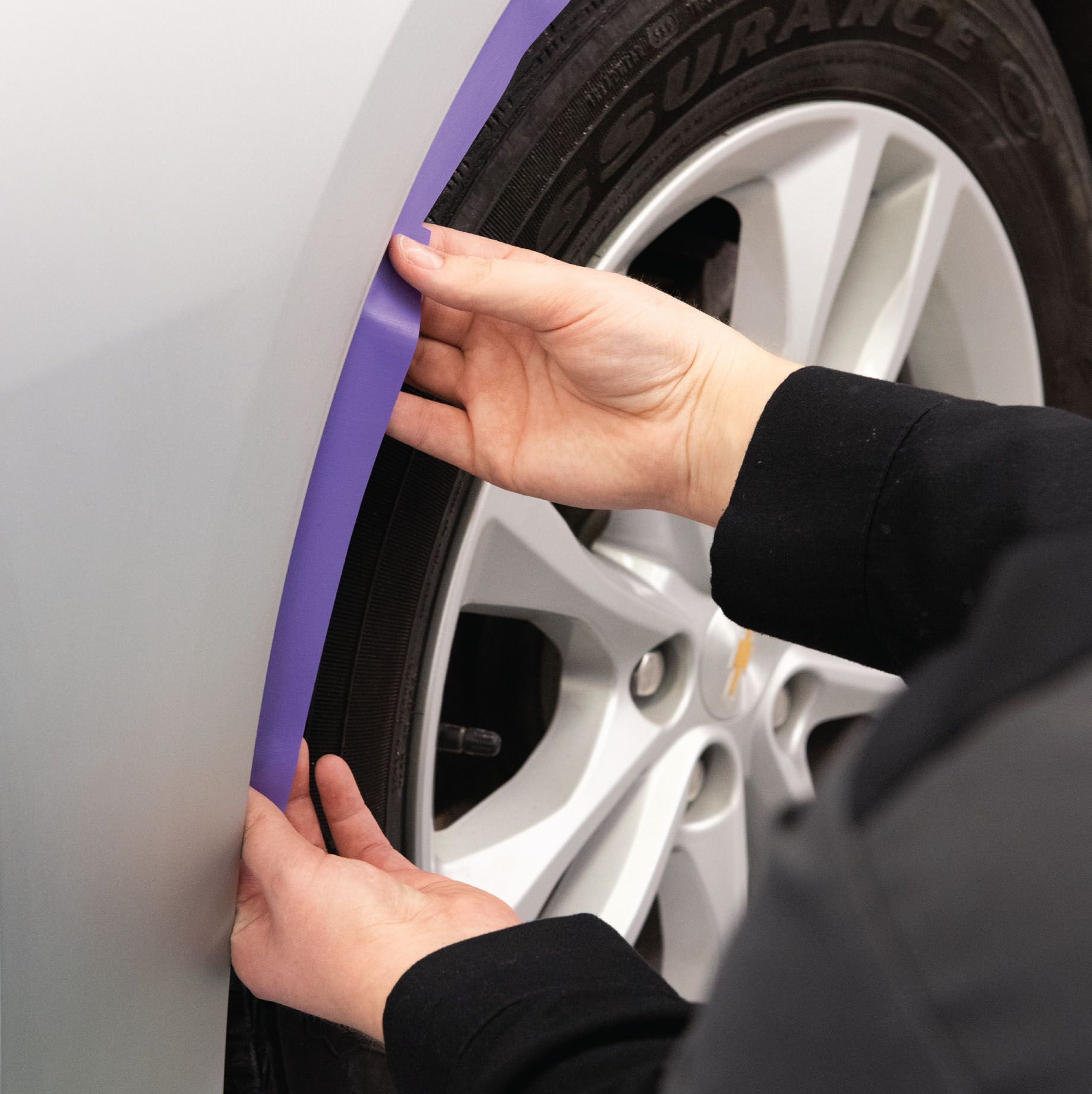 purple precision poly tape being applied to car wheel well trim